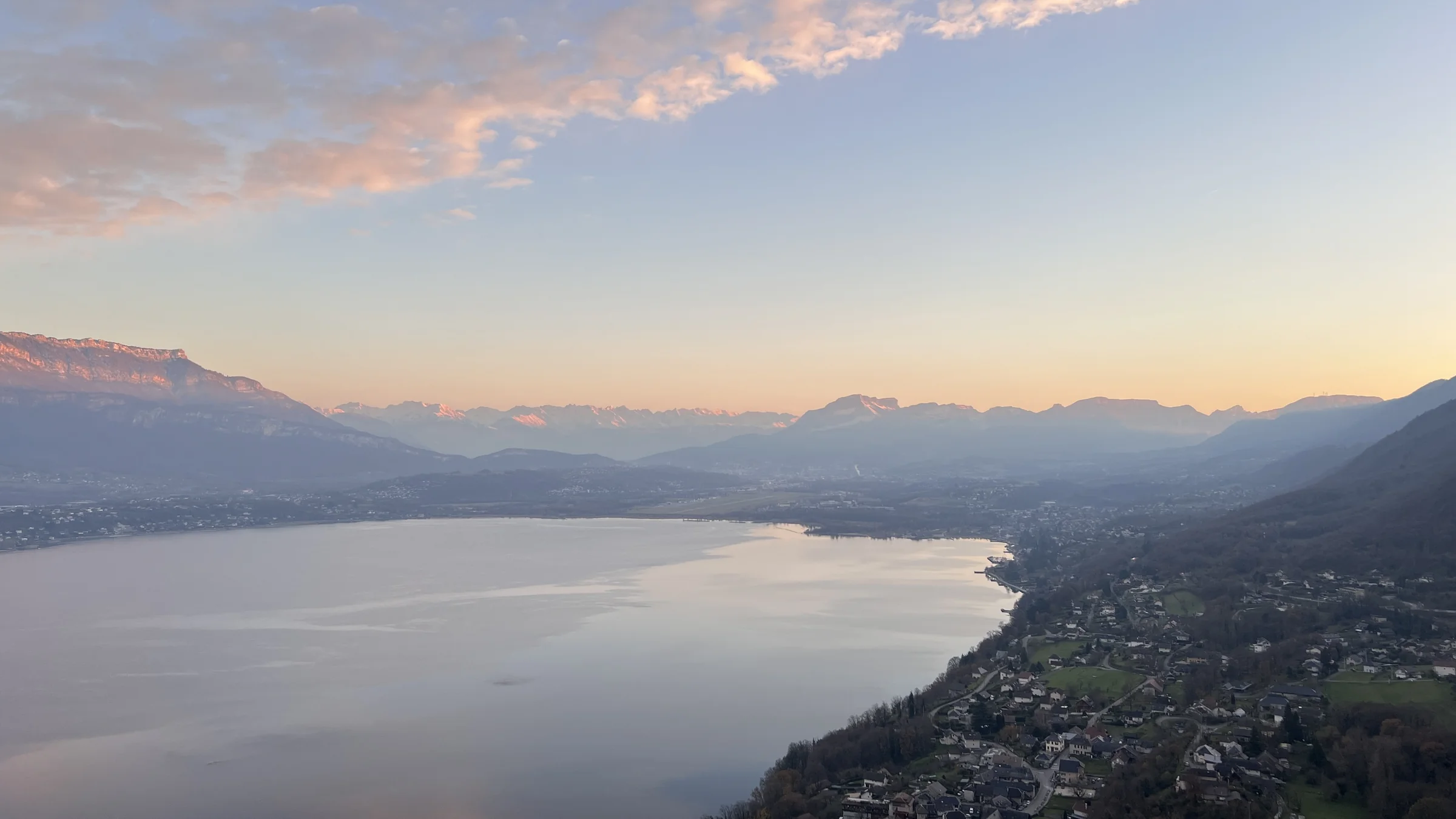 La rive ouest du lac du Bourget vue du ciel en fin de journée : le village de Bourdeau, le lac, et la chaîne de Belledonne à l'horizon