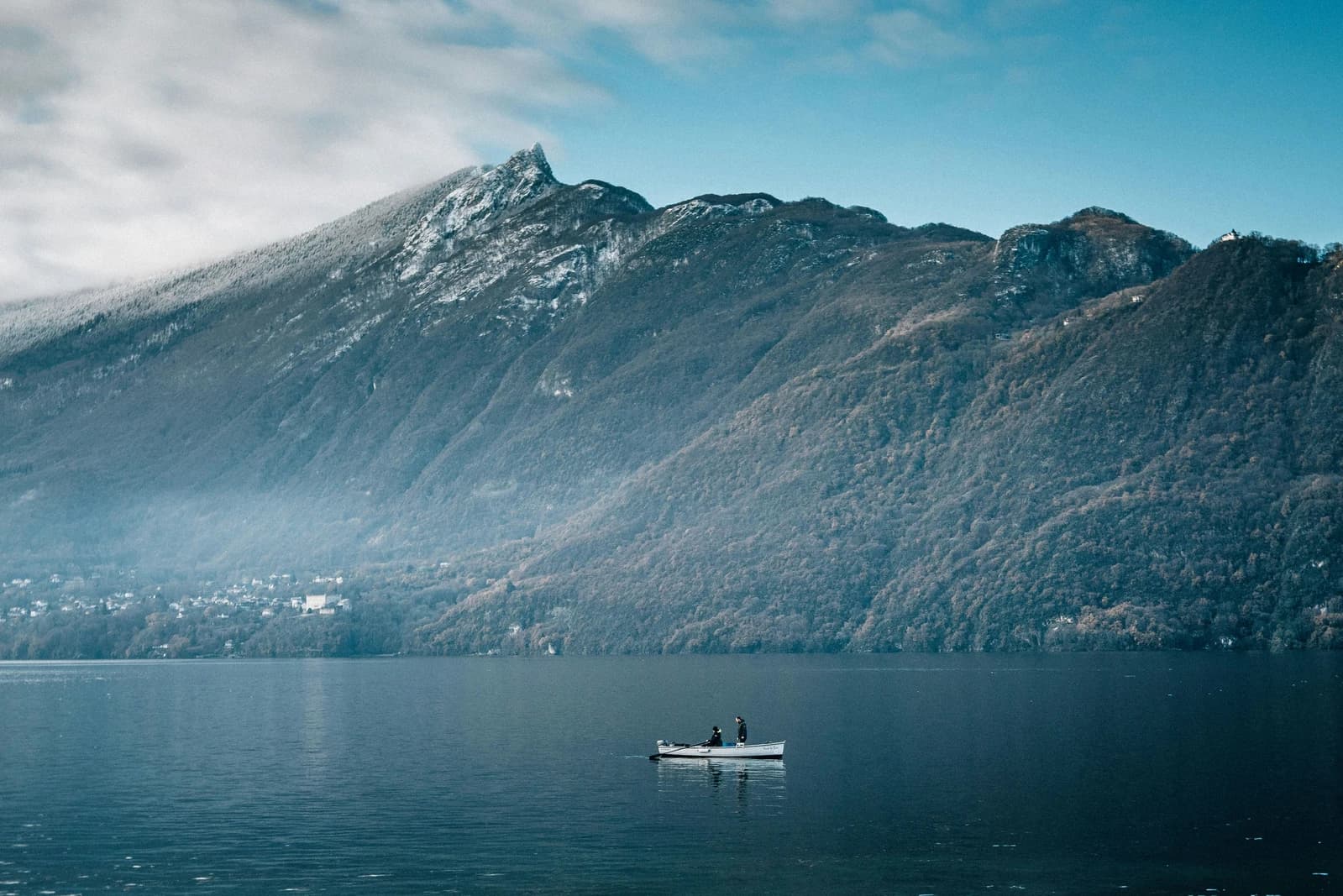 Lac du Bourget depuis la rive, barque sur le plan d'eau, massif du Revard en arrière-plan